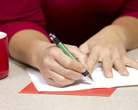 person writing on a card with a pen